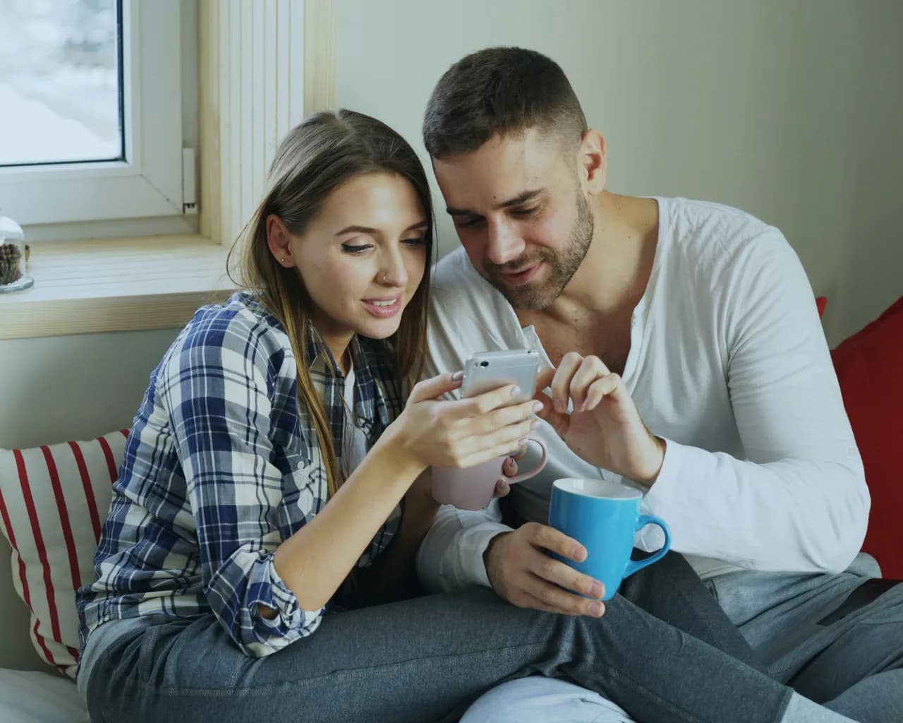 A couple reviewing their options on a phone at home