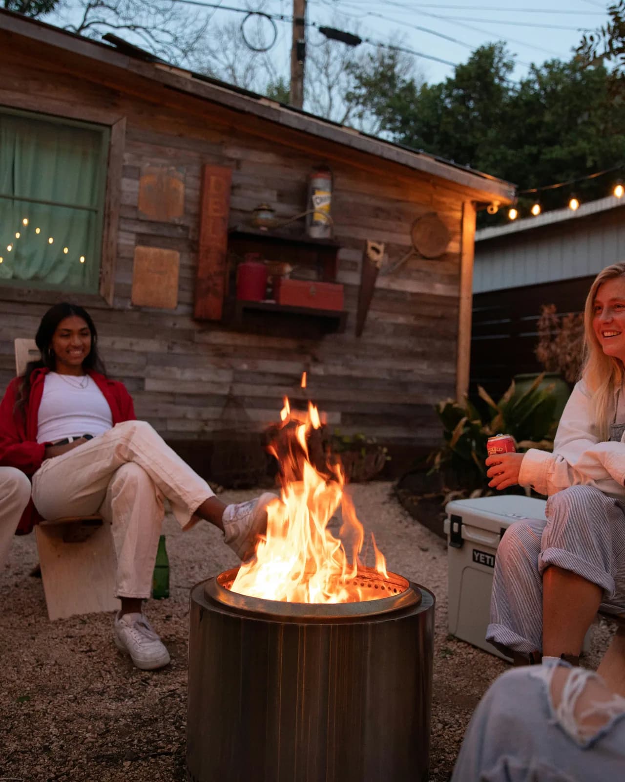 Friends gathered around a backyard fire pit