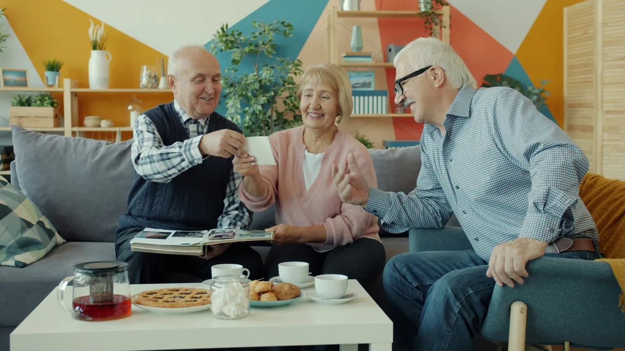 Retirees looking through a photo album at home